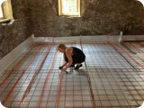 Attaching 1/2" pex tubing to the wire mesh for radiant heat flow through the main living room, kitchen & bath zones.