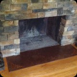 44  Mocha brown Skimstone decorative concrete fireplace hearth with ornamental corner accents.